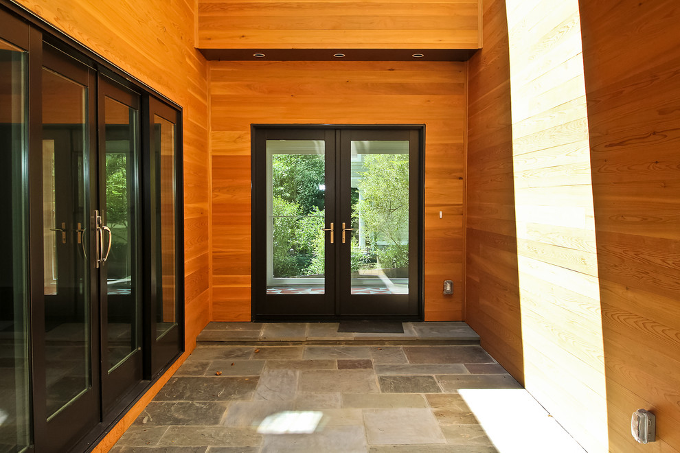 Design ideas for a contemporary entryway in DC Metro with slate floors, a double front door and wood walls.