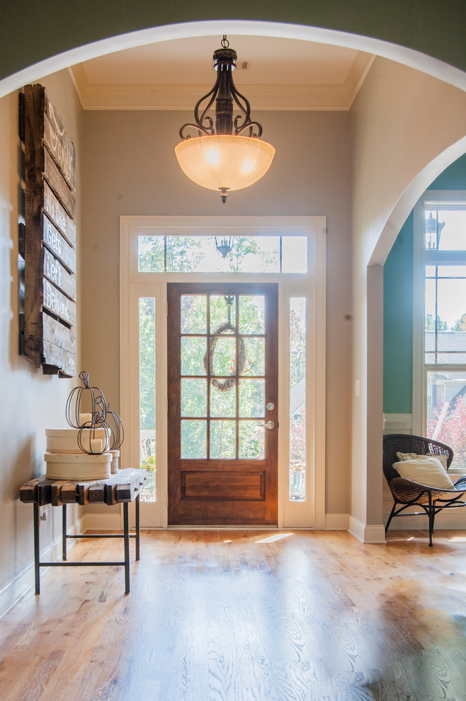 Traditional entryway in Atlanta with light hardwood floors and a single front door.