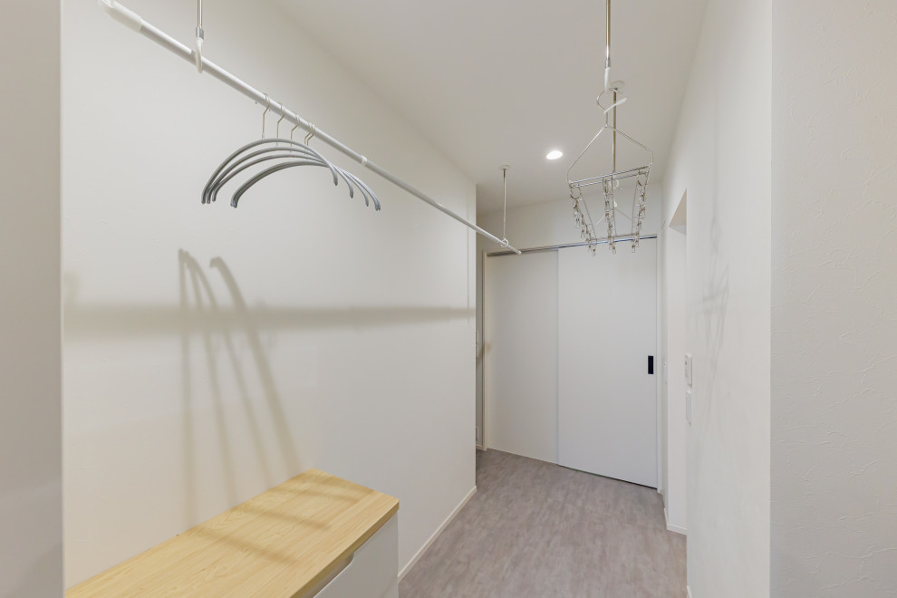 Inspiration for a mid-sized modern dedicated laundry room in Kobe with white walls and grey floor.
