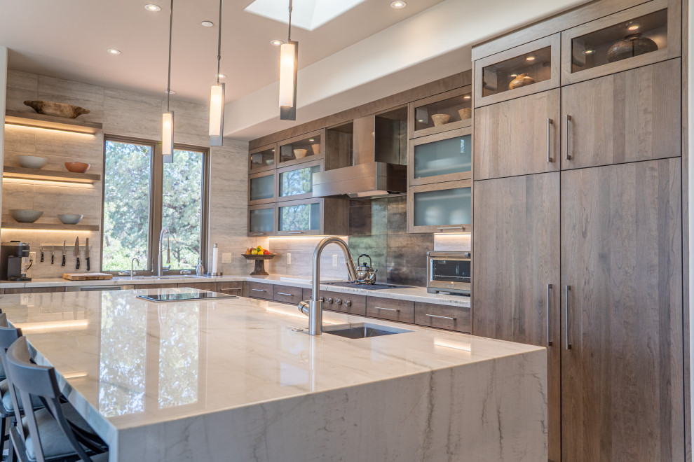 Photo of a large contemporary eat-in kitchen with an undermount sink, flat-panel cabinets, light wood cabinets, quartzite benchtops, white splashback, panelled appliances, with island and white benchtop.