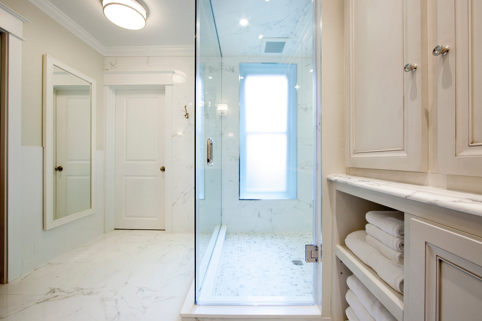 Design ideas for a mid-sized traditional master bathroom in Philadelphia with furniture-like cabinets, dark wood cabinets, a corner shower, a two-piece toilet, white tile, ceramic tile, white walls, marble floors, an undermount sink, marble benchtops, white floor and a hinged shower door.