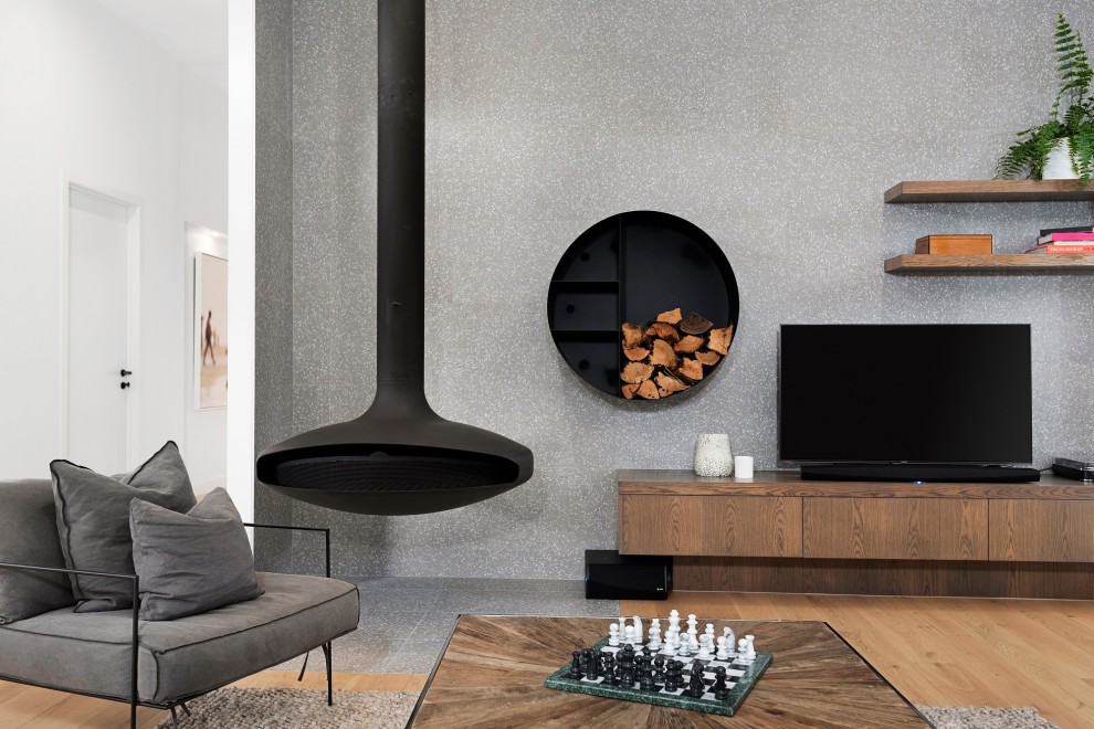 This is an example of a large modern open concept living room in Melbourne with grey walls, medium hardwood floors, a hanging fireplace, a tile fireplace surround, a wall-mounted tv, brown floor, timber and decorative wall panelling.