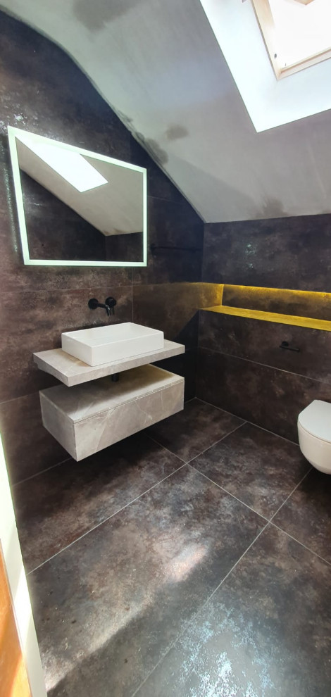 Photo of a mid-sized kids bathroom in Dublin with open cabinets, beige cabinets, a curbless shower, a wall-mount toilet, multi-coloured tile, travertine, multi-coloured walls, terrazzo floors, a vessel sink, wood benchtops, multi-coloured floor, an open shower, beige benchtops, a single vanity and a floating vanity.