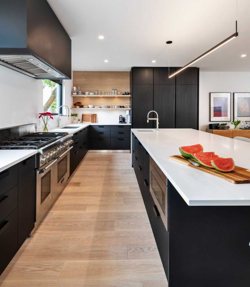 Contemporary kitchen in Ottawa with flat-panel cabinets, black cabinets, quartzite benchtops, with island and white benchtop.
