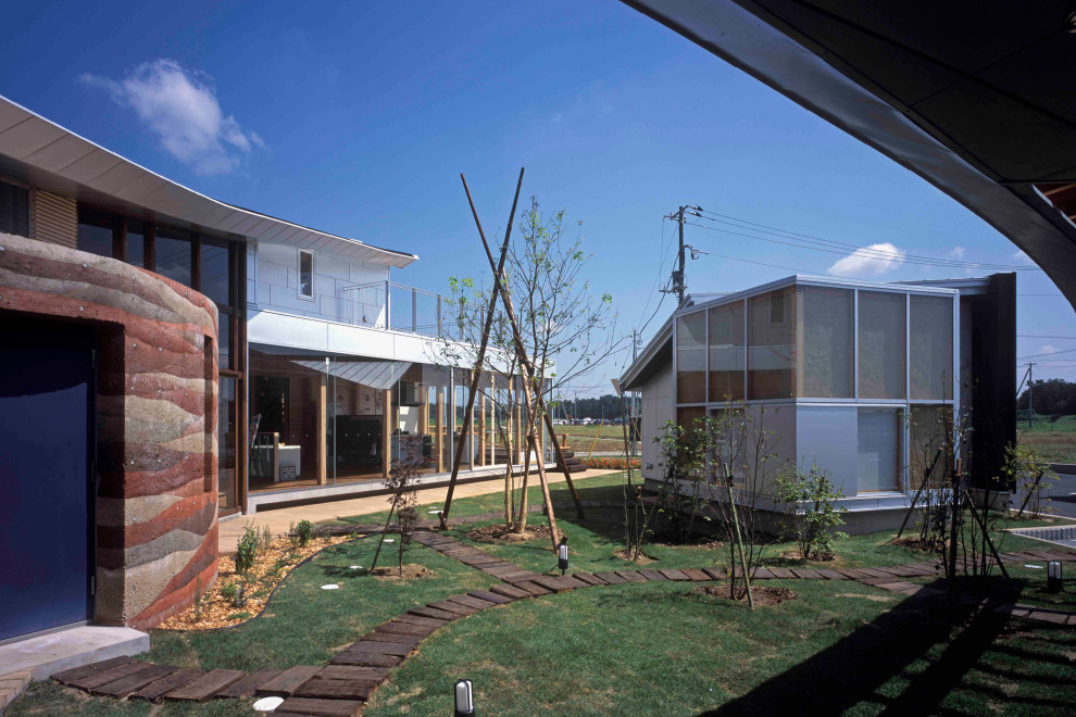 Réalisation d'une terrasse en bois design de taille moyenne avec une cour et une pergola.