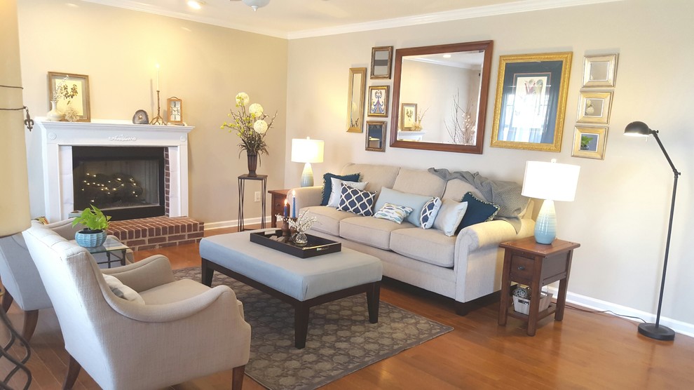 Inspiration for a mid-sized transitional enclosed living room in Other with beige walls, medium hardwood floors, a standard fireplace, a wood fireplace surround and no tv.