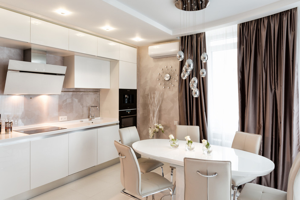 This is an example of a contemporary single-wall eat-in kitchen in Other with an integrated sink, flat-panel cabinets, white cabinets, beige splashback, stone tile splashback, black appliances and no island.