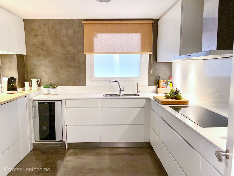 Photo of a mid-sized contemporary u-shaped separate kitchen with a double-bowl sink, shaker cabinets, white cabinets, stainless steel benchtops, white splashback, limestone splashback, stainless steel appliances, concrete floors, grey floor and white benchtop.