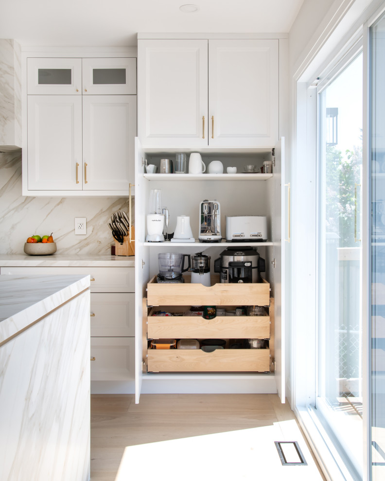 Mid-sized transitional galley light wood floor and beige floor open concept kitchen photo in Ottawa with an undermount sink, recessed-panel cabinets, white cabinets, quartz countertops, white backsplash, porcelain backsplash, stainless steel appliances, an island and white countertops