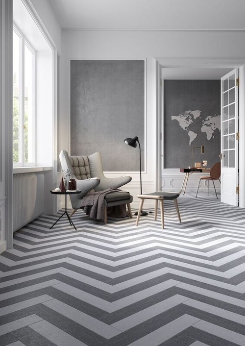 grey chair on herringbone carpet in grey and white room