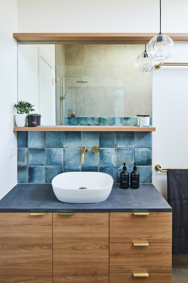 Contemporary bathroom in Melbourne with flat-panel cabinets, medium wood cabinets, blue tile, white walls, a vessel sink, grey floor, grey benchtops and a single vanity.