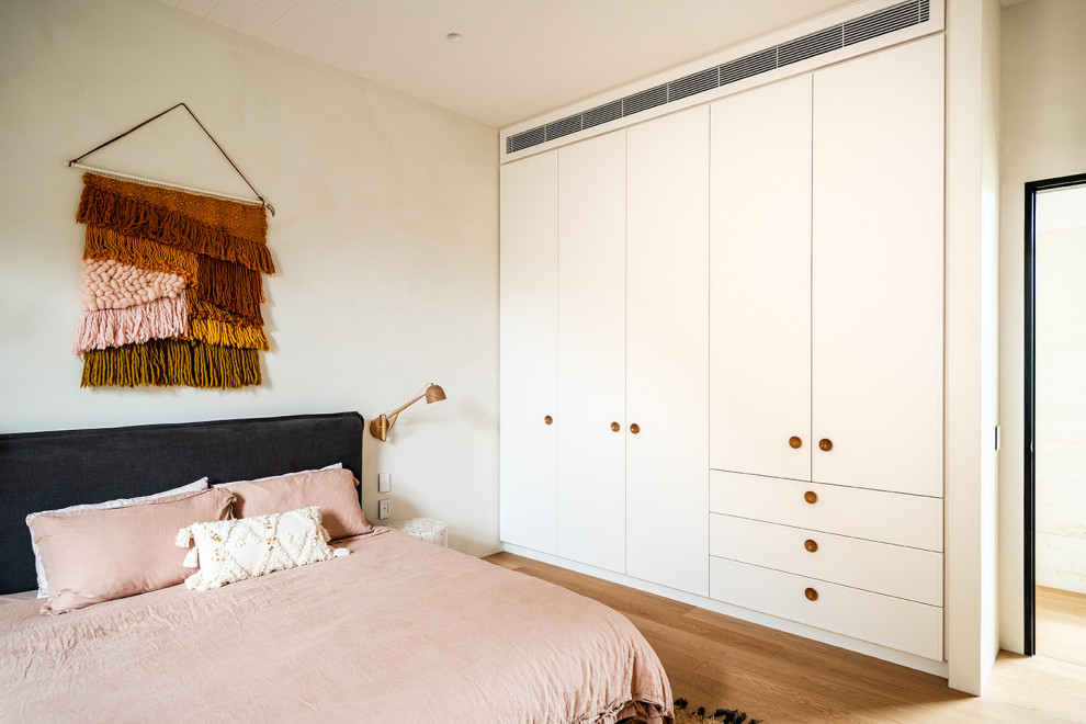 Inspiration pour une chambre d'amis design de taille moyenne avec un mur blanc, parquet clair, un sol beige et un plafond en lambris de bois.