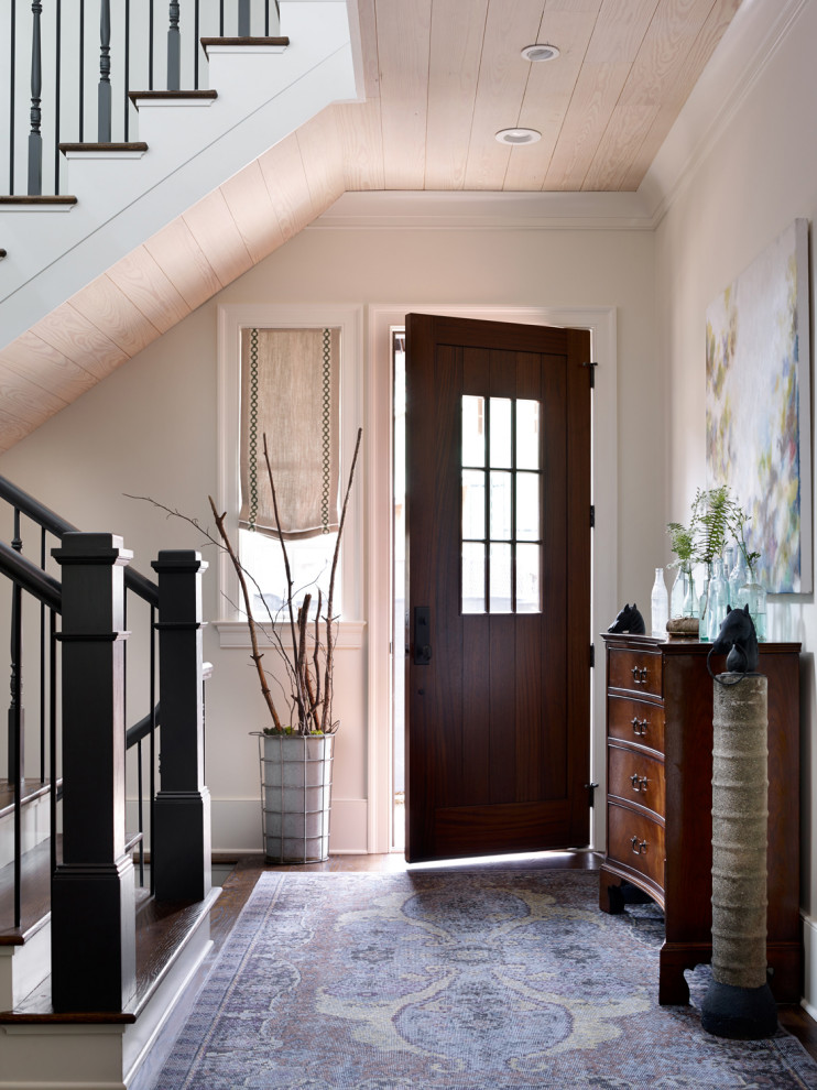 Idee per un ingresso o corridoio tradizionale con pareti bianche, parquet scuro, una porta singola, una porta in legno scuro, pavimento marrone e soffitto in legno