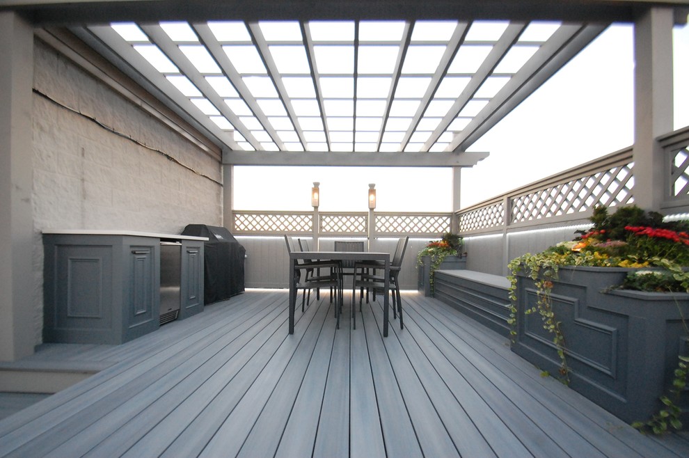 Example of a large transitional rooftop outdoor kitchen deck design in Chicago with a pergola
