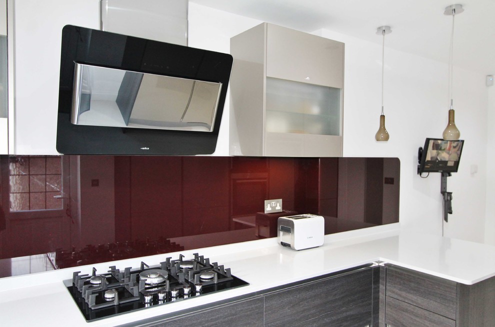 This is an example of a mid-sized modern u-shaped eat-in kitchen in London with a drop-in sink, flat-panel cabinets, brown cabinets, quartzite benchtops, glass sheet splashback, stainless steel appliances, a peninsula and yellow floor.