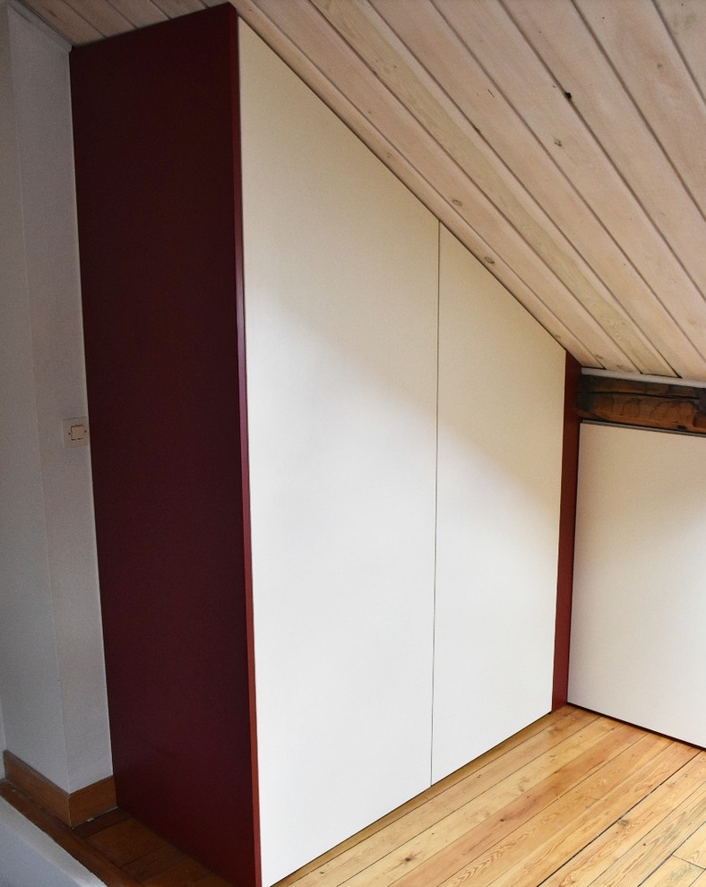 This is an example of a large contemporary loft-style bedroom in Lille with light hardwood floors and no fireplace.