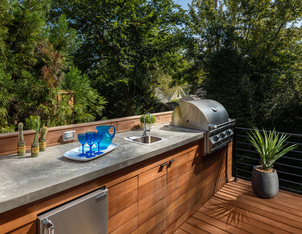 This is an example of a large contemporary backyard deck in Atlanta with an outdoor kitchen and no cover.