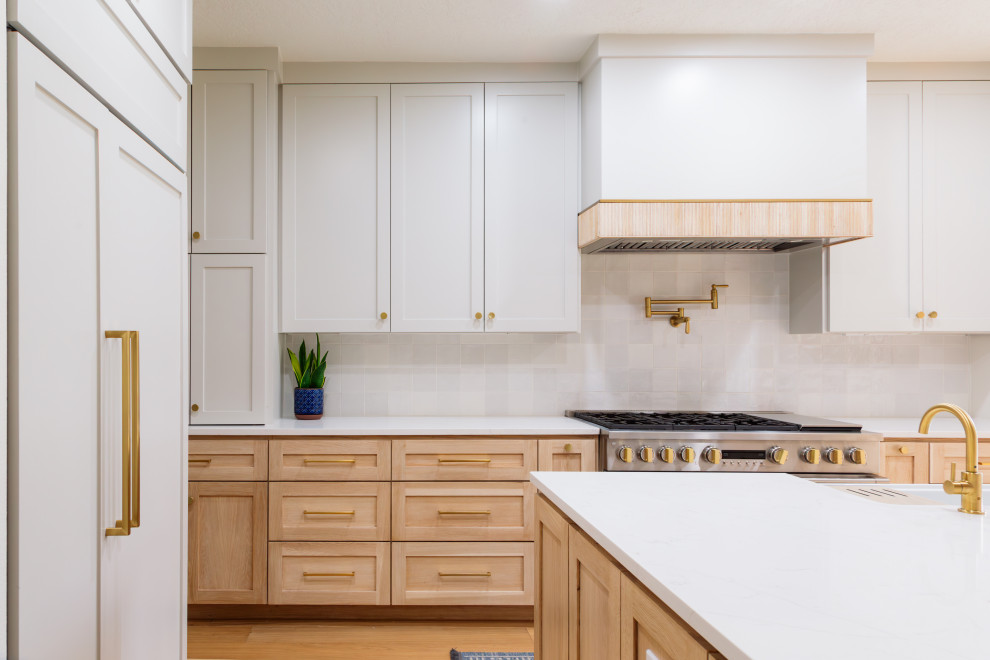 Inspiration for a mid-sized transitional light wood floor open concept kitchen remodel in Houston with light wood cabinets, white backsplash, porcelain backsplash, paneled appliances, an island and white countertops