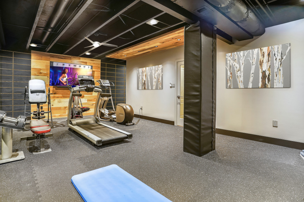 Photo of a medium sized industrial multi-use home gym in DC Metro with grey walls, grey floors and exposed beams.