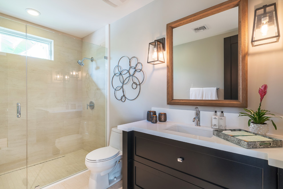 Inspiration for a small transitional bathroom in Orange County with shaker cabinets, black cabinets, an alcove shower, a one-piece toilet, beige tile, porcelain tile, grey walls, an undermount sink, solid surface benchtops, beige floor and a hinged shower door.