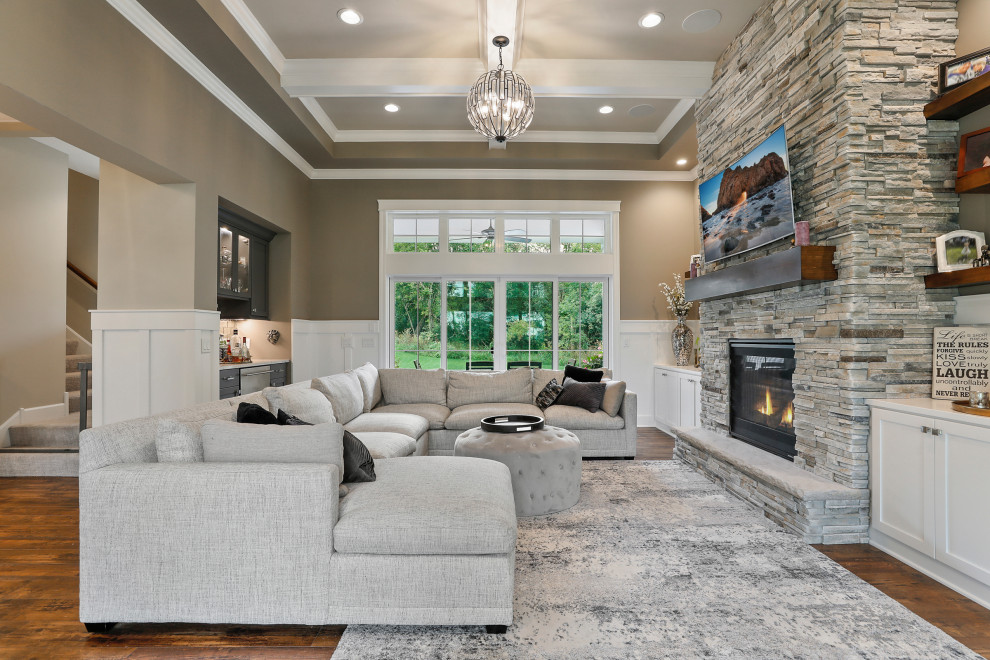 This is an example of a mid-sized country open concept living room in New York with beige walls, medium hardwood floors and a standard fireplace.