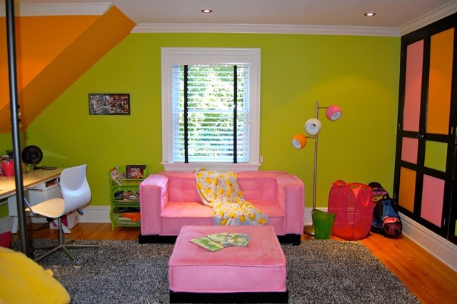 This is an example of a mid-sized eclectic gender-neutral kids' room for kids 4-10 years old in New York with multi-coloured walls and carpet.