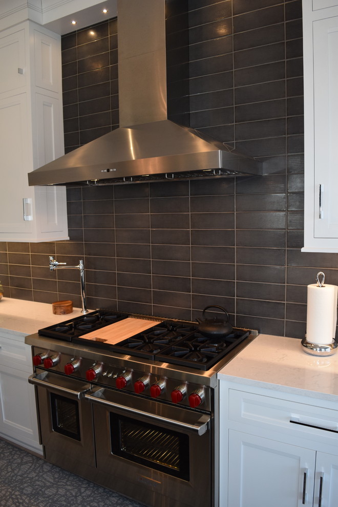 Large transitional l-shaped light wood floor and multicolored floor eat-in kitchen photo in Chicago with beaded inset cabinets, white cabinets, quartz countertops, black backsplash, ceramic backsplash, stainless steel appliances and an island