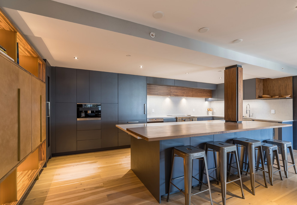 Modern Kitchen with Handleless Cabinets - In this modern kitchen area, the gray cabinets and island created a focal point in this space, while the wood materials accents a fresh look that contrasts the gray. Since the appliances are built in with the cabinets, it gives an open space to move around.  

Built by ULFBUILT. Contact us today to learn more.