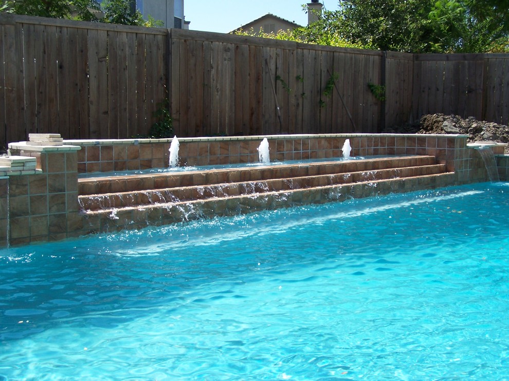 Mid-sized traditional backyard rectangular lap pool in Kansas City with a water feature.