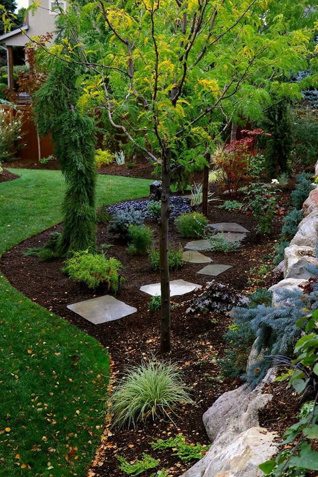 Photo of a large country backyard partial sun formal garden in Salt Lake City with a garden path and natural stone pavers.