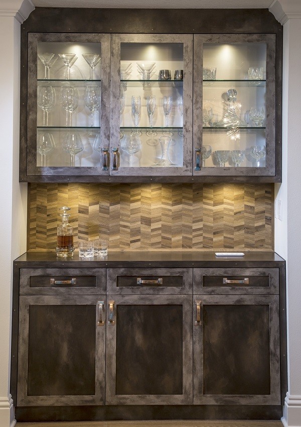 Design ideas for a mid-sized industrial single-wall wet bar in Tampa with shaker cabinets, dark wood cabinets, solid surface benchtops, beige splashback, timber splashback, medium hardwood floors and brown floor.