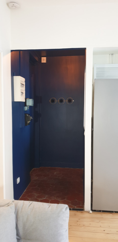 Diseño de vestíbulo tradicional renovado pequeño con paredes azules, suelo de baldosas de terracota, puerta simple, puerta azul y suelo rojo
