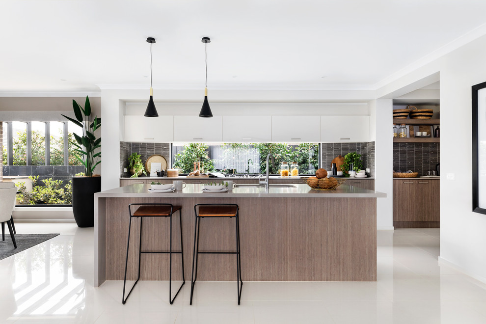 Design ideas for a contemporary open plan kitchen in Melbourne with an undermount sink, flat-panel cabinets, white cabinets, window splashback, with island, white floor and grey benchtop.