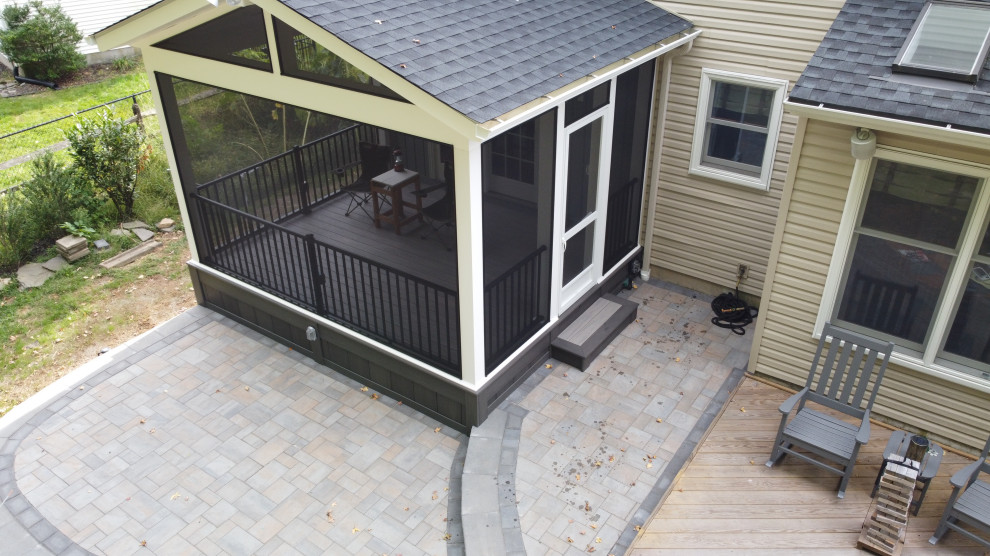 Immagine di un piccolo portico stile americano dietro casa con un portico chiuso, pavimentazioni in cemento, un tetto a sbalzo e parapetto in metallo