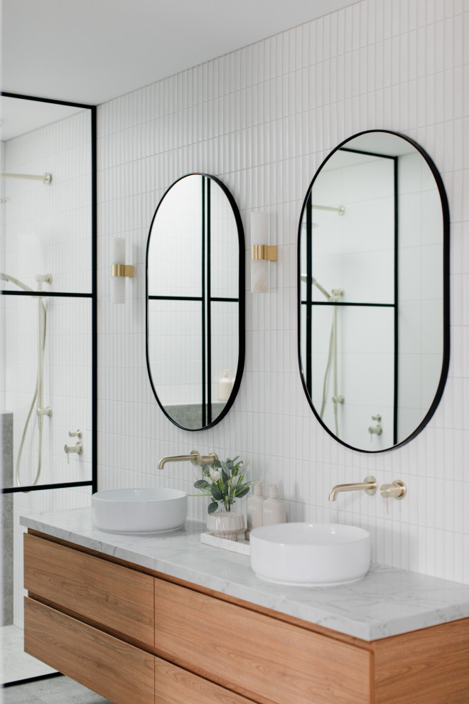 Photo of a contemporary bathroom in Melbourne with flat-panel cabinets, medium wood cabinets, an alcove shower, white tile, concrete floors, a vessel sink, grey floor, white benchtops, a double vanity and a floating vanity.