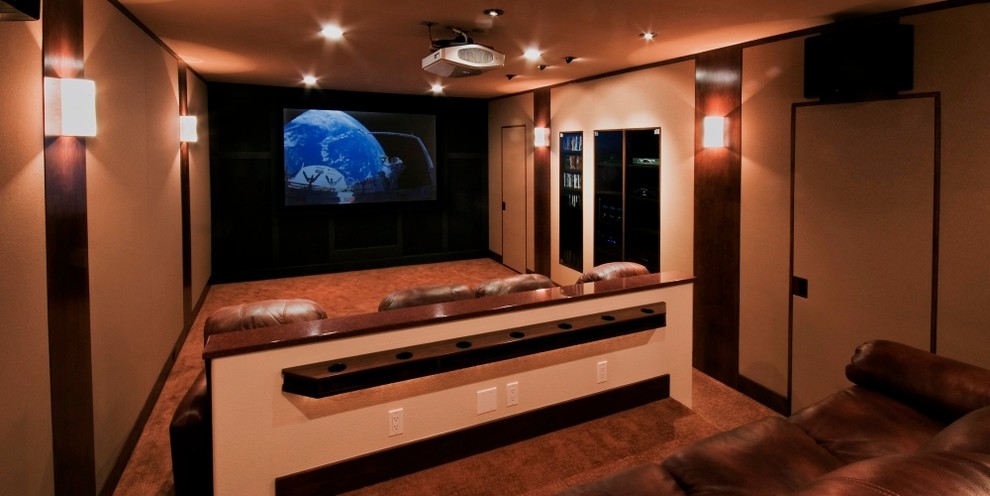 Photo of a large traditional enclosed home theatre in Denver with beige walls, carpet and a projector screen.