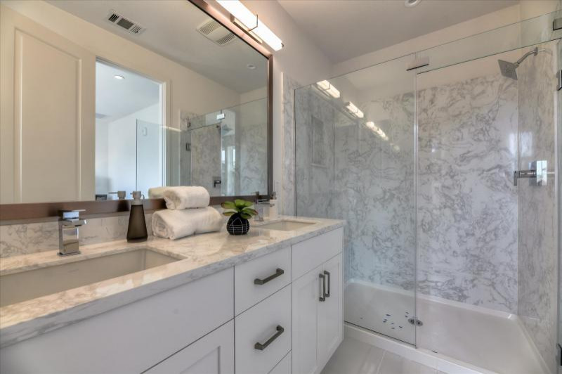 Inspiration for a master double-sink alcove shower remodel in San Francisco with shaker cabinets, white cabinets, an undermount sink, a hinged shower door, gray countertops and a built-in vanity