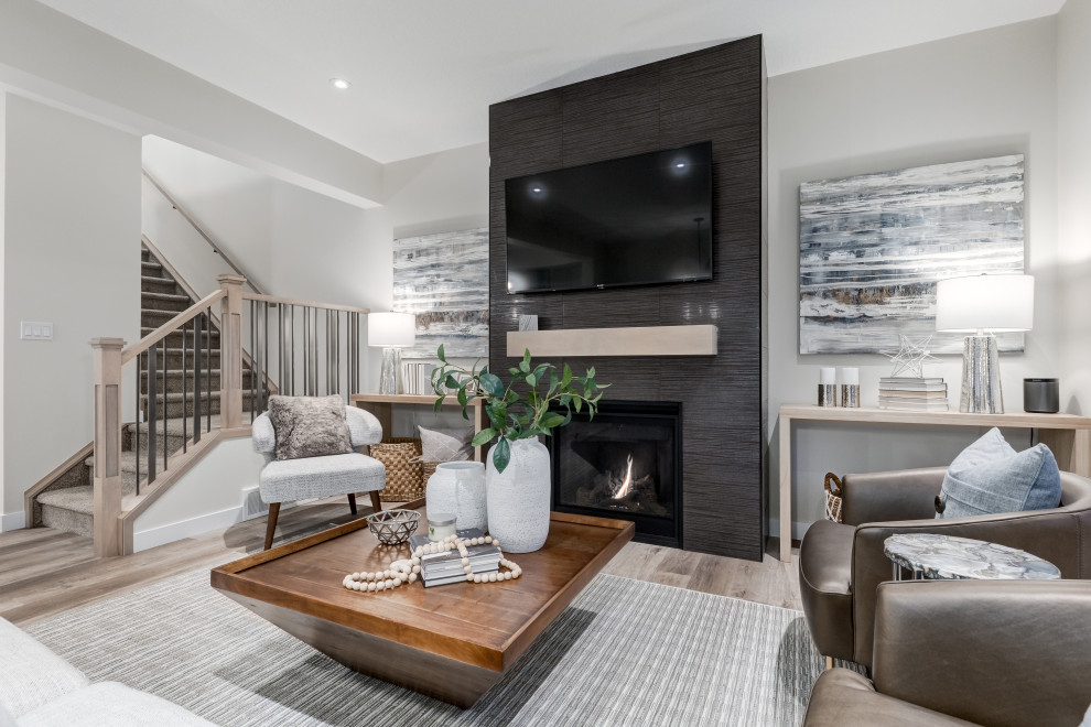 This is an example of a contemporary open plan living room in Calgary with grey walls, vinyl flooring, a tiled fireplace surround, a wall mounted tv, grey floors and a two-sided fireplace.