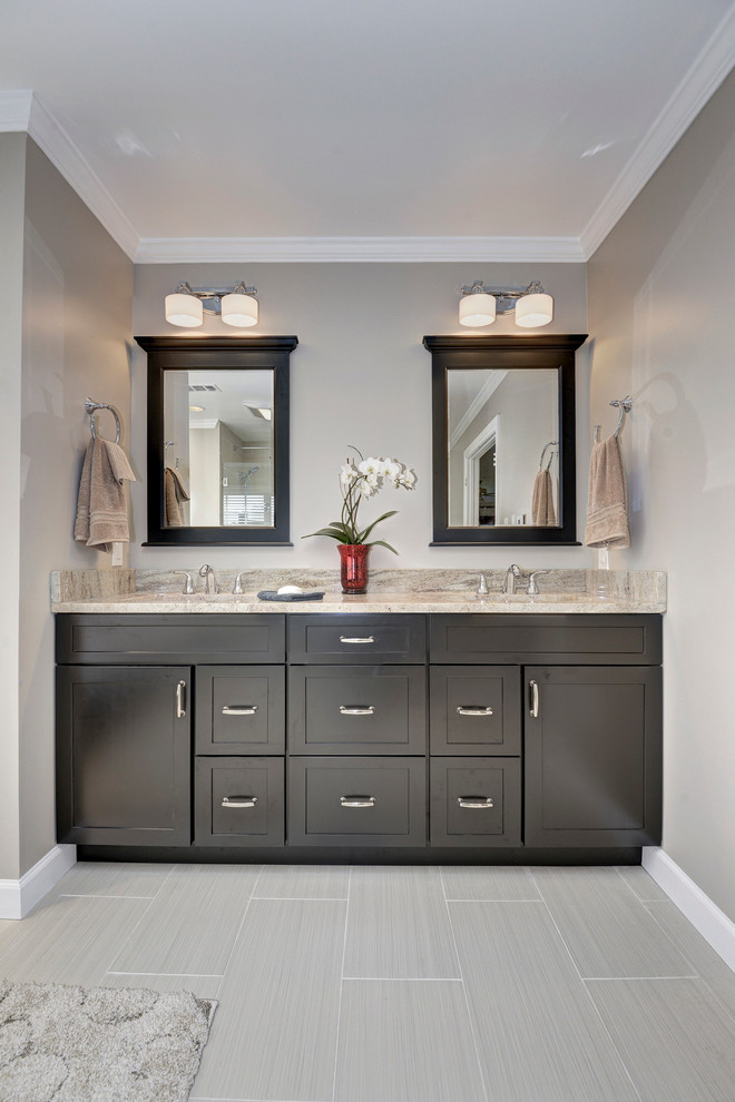 This is an example of a contemporary master bathroom in DC Metro with shaker cabinets, dark wood cabinets, grey walls, porcelain floors, an undermount sink, granite benchtops and grey floor.