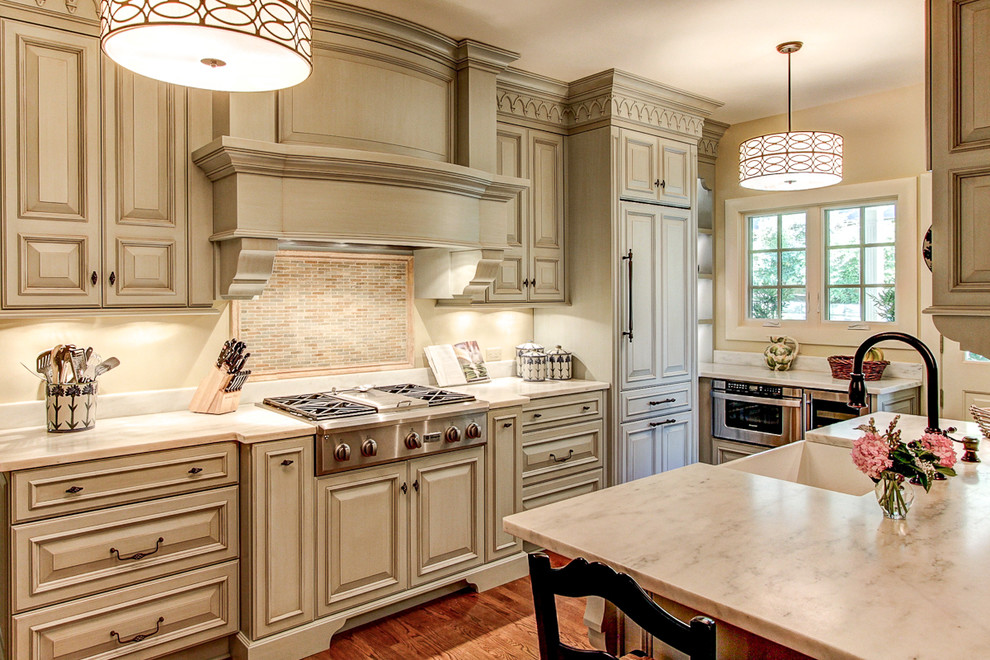 This is an example of a traditional kitchen in Louisville with an undermount sink, marble benchtops and raised-panel cabinets.