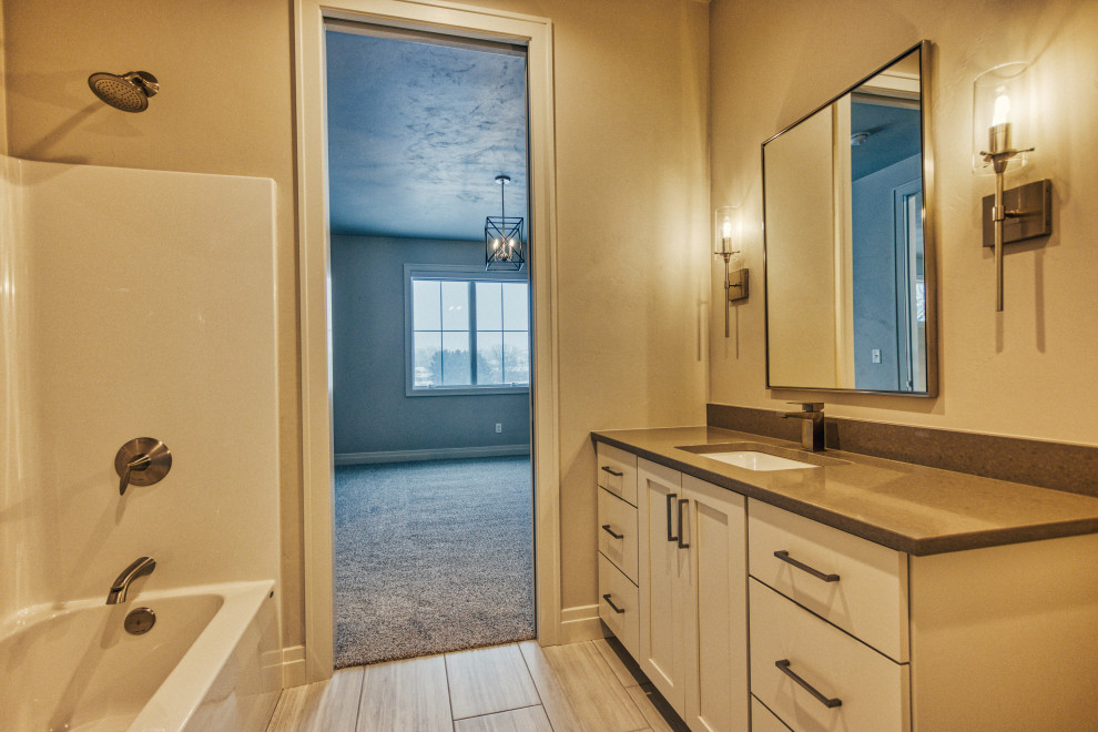 Inspiration for a transitional kids' ceramic tile and gray floor alcove bathtub remodel with shaker cabinets, white cabinets, a two-piece toilet, gray walls, an undermount sink, quartz countertops and gray countertops