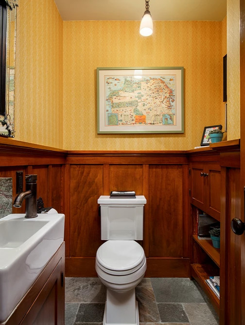 Inspiration för små amerikanska vitt toaletter, med skåp i shakerstil, skåp i mellenmörkt trä, en toalettstol med separat cisternkåpa, gula väggar, skiffergolv, ett integrerad handfat och flerfärgat golv