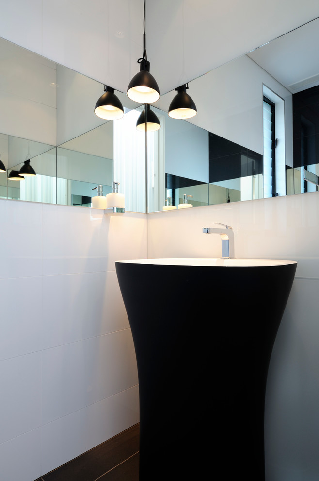 Small contemporary powder room in Sydney with a pedestal sink, white tile, ceramic tile and white walls.