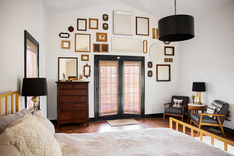 Eclectic bedroom in Nashville with white walls, dark hardwood floors and brown floor.