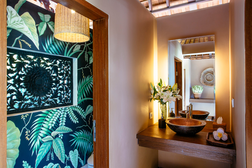 Photo of a small tropical powder room in San Diego with a vessel sink, wood benchtops and brown benchtops.