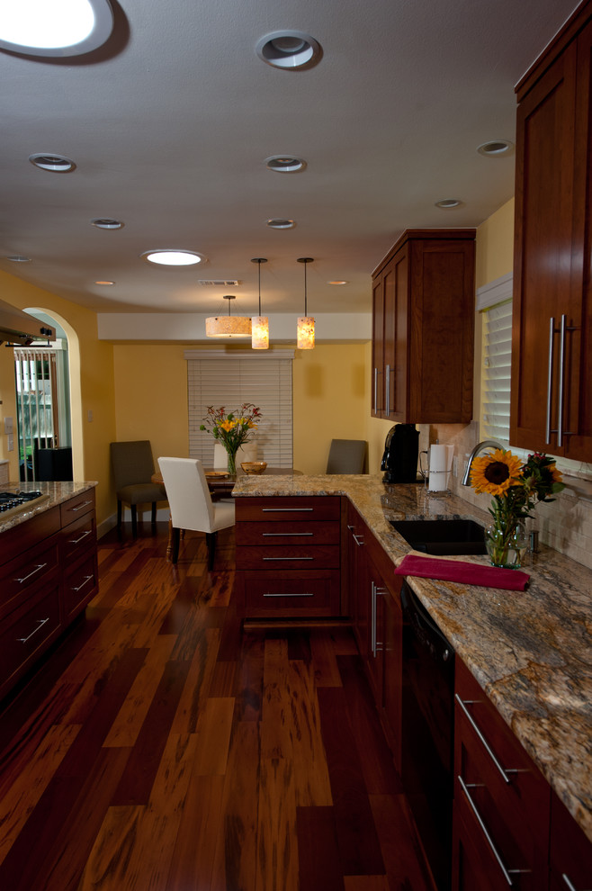 Eat-in kitchen - transitional galley medium tone wood floor eat-in kitchen idea in Austin with an undermount sink, recessed-panel cabinets, medium tone wood cabinets, granite countertops, beige backsplash, ceramic backsplash, yellow walls and no island
