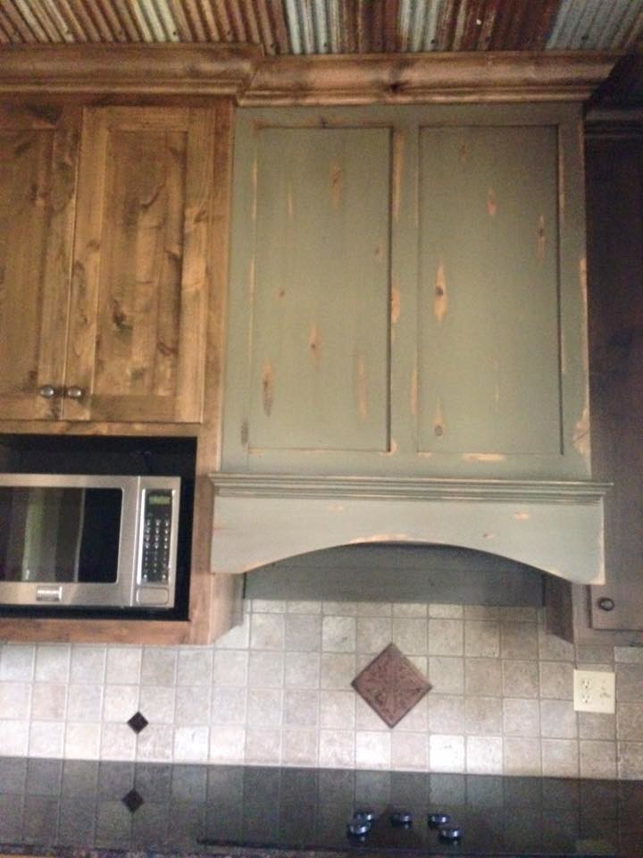 Inspiration for a rustic enclosed kitchen remodel with flat-panel cabinets, distressed cabinets, granite countertops, beige backsplash, stone tile backsplash and stainless steel appliances