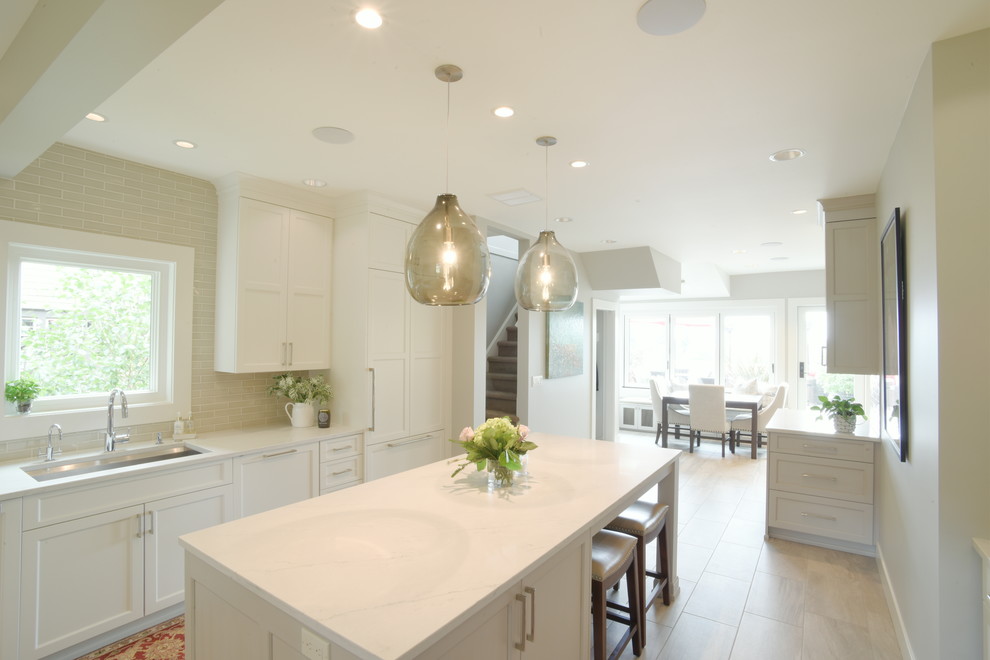 Inspiration for a transitional ceramic tile kitchen remodel in Seattle with shaker cabinets, white cabinets, quartzite countertops, subway tile backsplash, stainless steel appliances, an island and white countertops