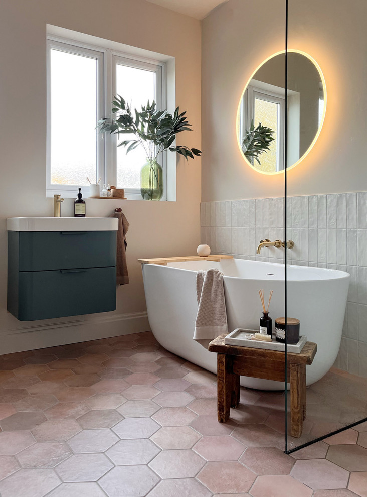 Idéer för ett modernt badrum, med släta luckor, gröna skåp, ett fristående badkar, en öppen dusch, en toalettstol med separat cisternkåpa, vit kakel, porslinskakel, beige väggar, klinkergolv i keramik, brunt golv och med dusch som är öppen
