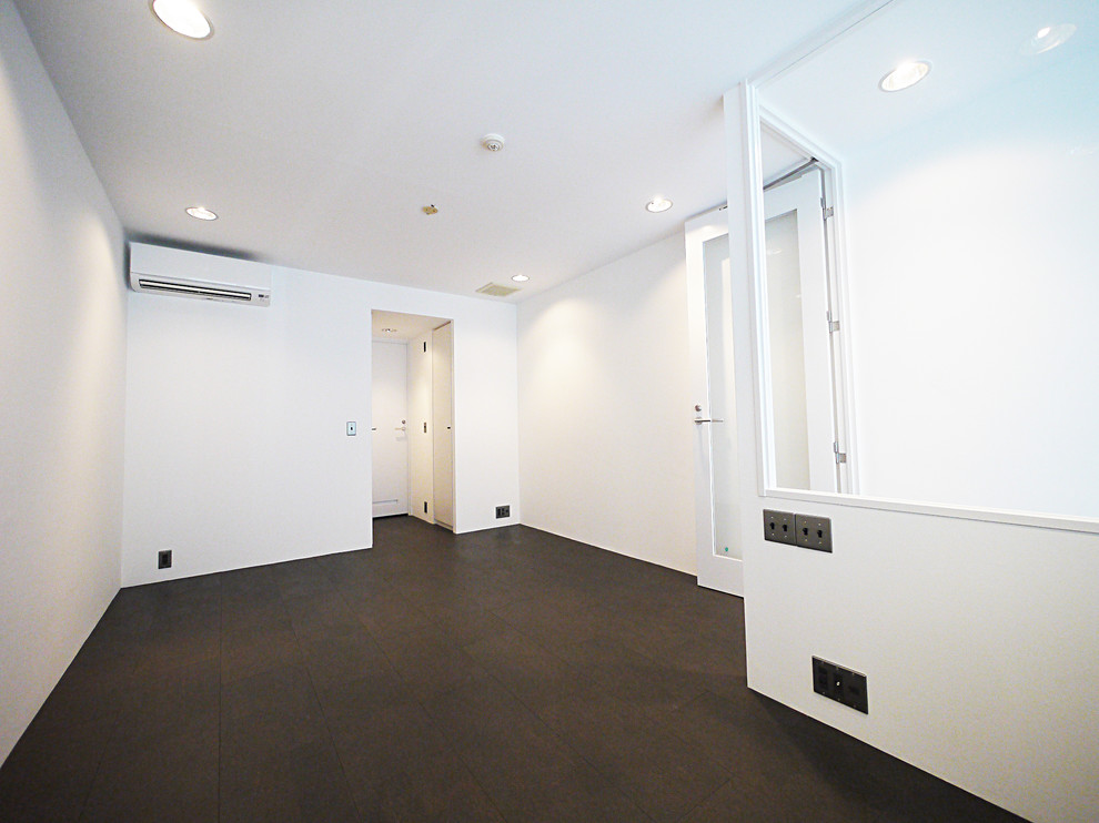 Photo of a modern master bedroom in Tokyo with white walls, cork floors and black floor.